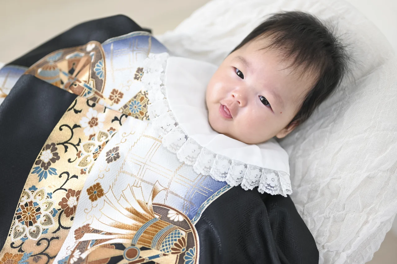 黒と金の祝い着をまとった赤ちゃんのお宮参り写真|豊橋店