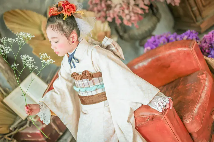 かすみ草を持ち目を閉じる着物の女の子