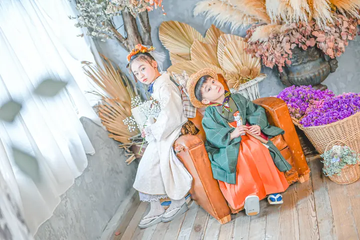 袴姿の男の子と着物の姉がソファで並ぶ