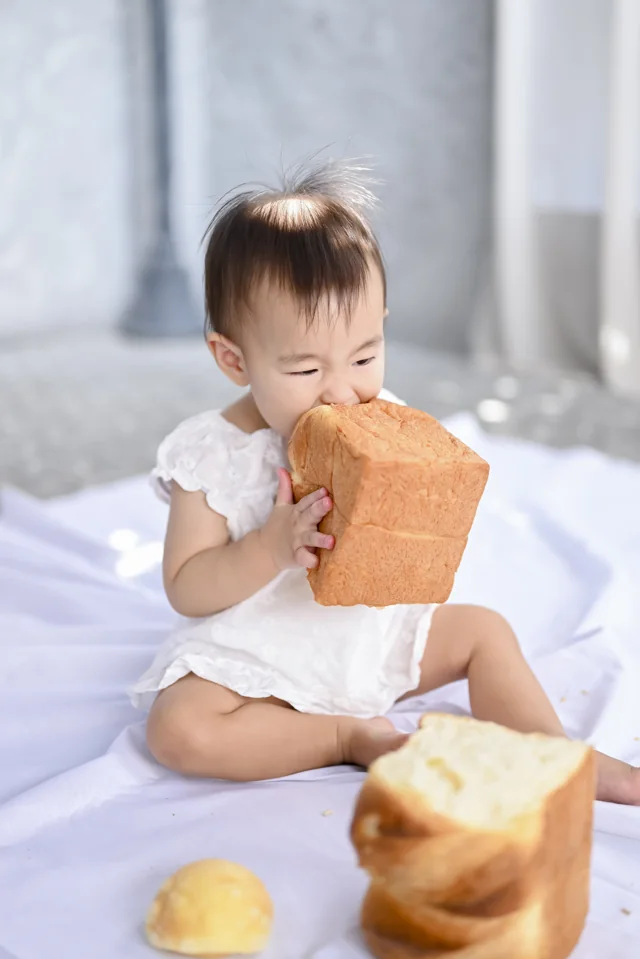 食パンを両手で持ってかじるお子さま|豊川店